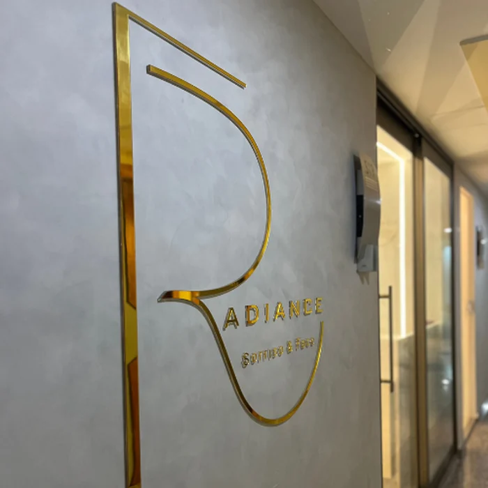Logo do Instituto Radiance em relevo dourado na parede