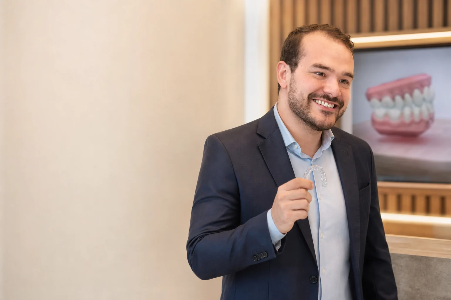 Dr. João Quirino segurando um alinhador transparente no consultório